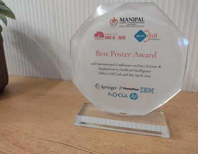 A trophy for 'Best Poster Award' in front of a white background on a wooden table